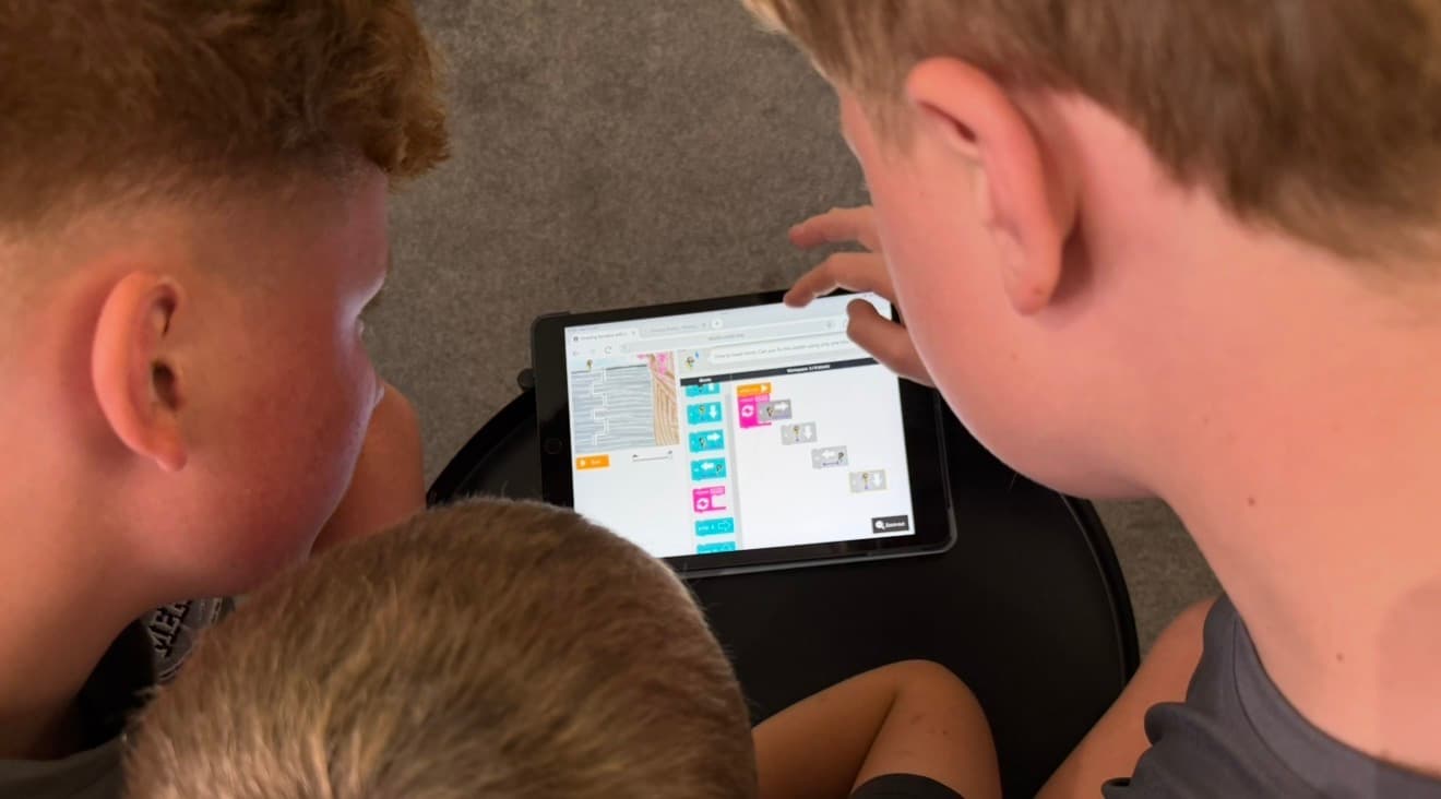 Pupils collaborating on a tablet coding activity