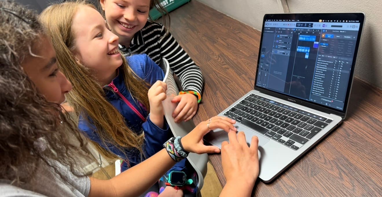 Pupils working together on a laptop music production task