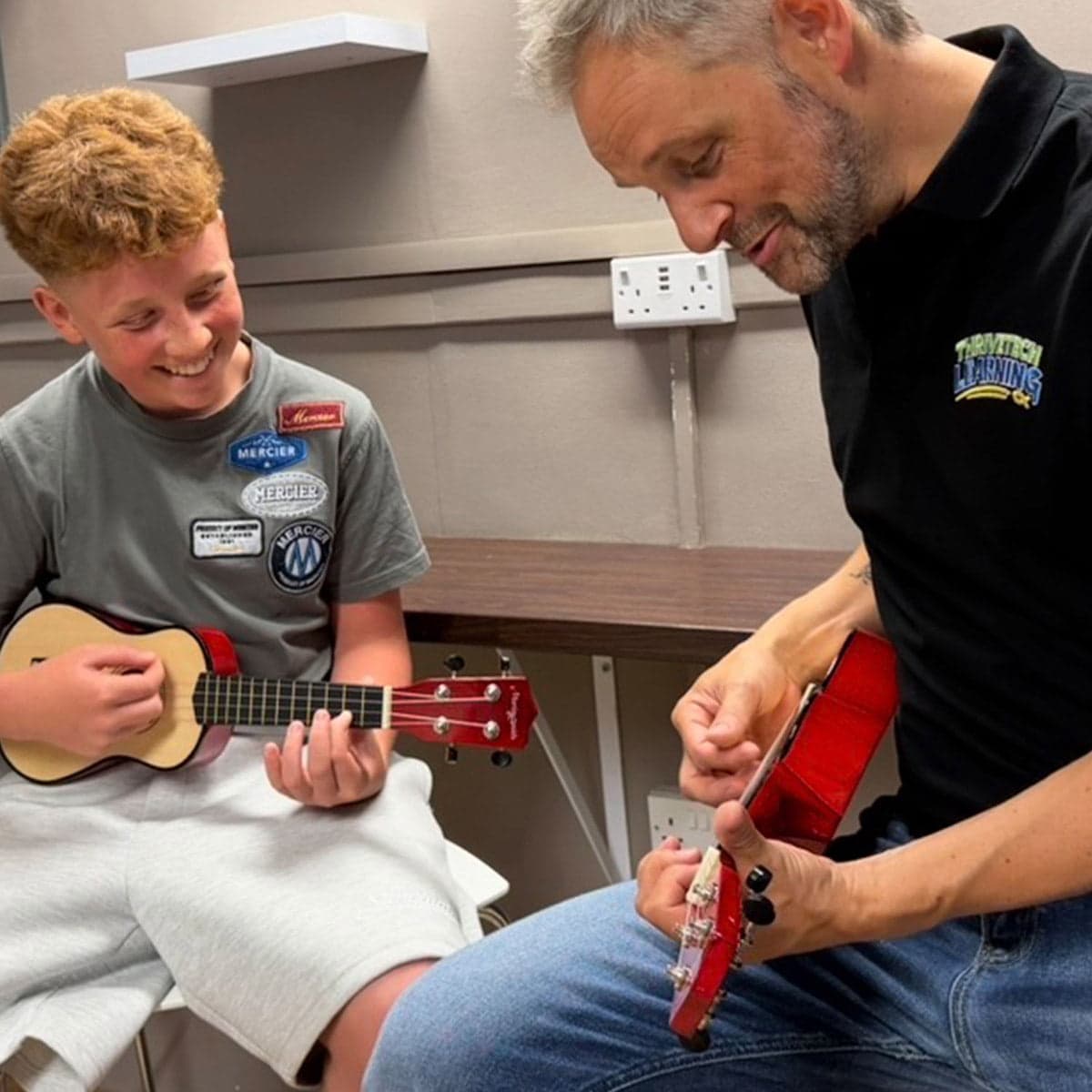 Pupil and tutor learning ukulele together in a 1-1 music session