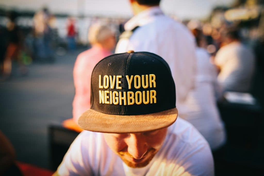 A community member wearing a cap embroidered with 'Love Your Neighbour'